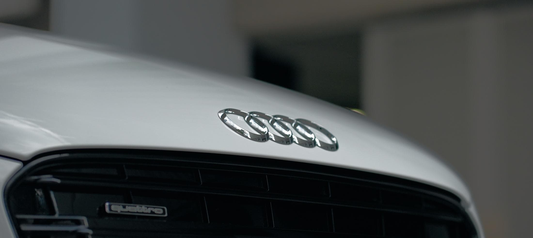 The quattro badge and grille of a white Audi, up close
