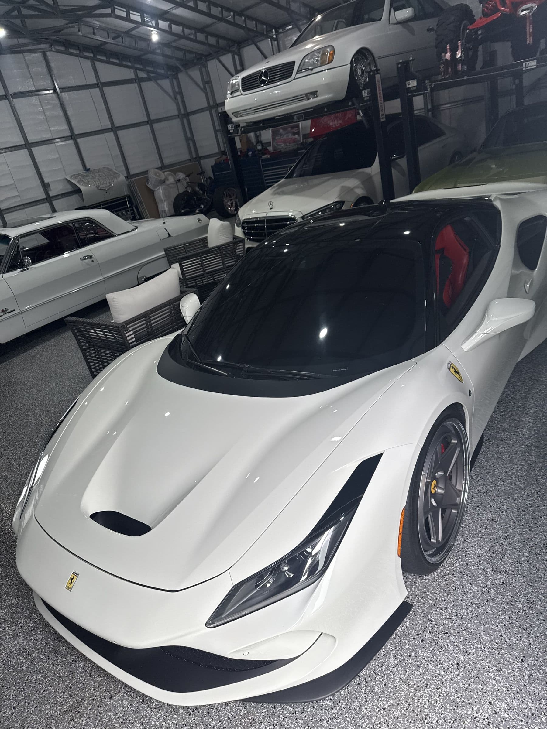 A white Ferrari F8 Tributo parked in a garage, seen from the front