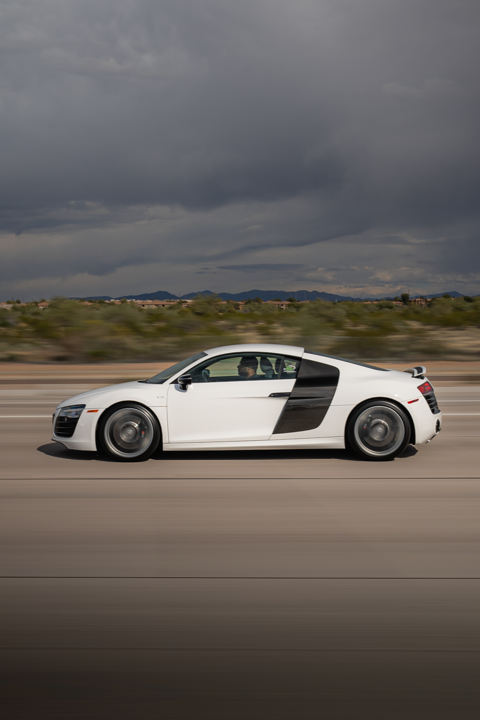 White Audi R8 V10 side profile rolling shot on desert highway, stormy sky